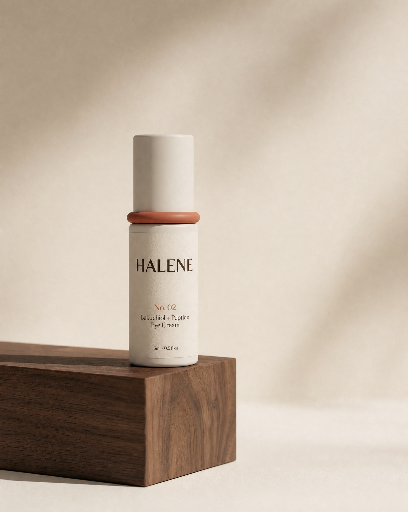 HALENE No. 02 Bakuchiol + Peptide Eye Cream with terracotta accent ring on a walnut wood block