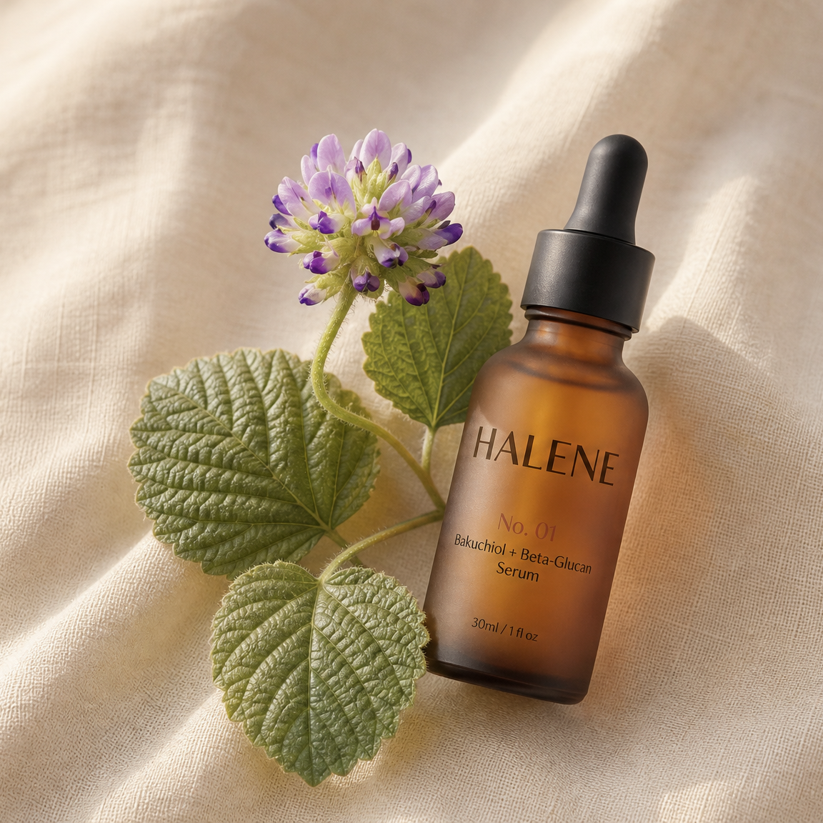 HALENE No. 01 Serum with a fresh babchi sprig and purple flower on cream linen